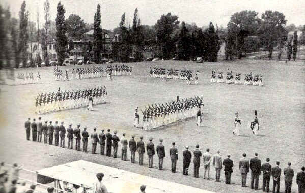 The cadets and graduates drill on the parade ground before a reviewing body of faculty and alumni of the college, while friends in the grandstand watch. - Photo from The Delaware County Advocate, June 1942